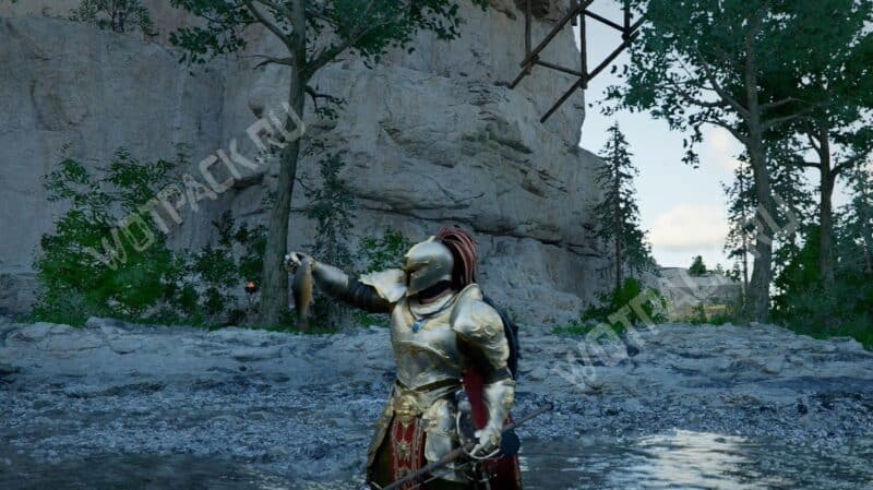 Клифф стоит по колено в реке и держит рыбу